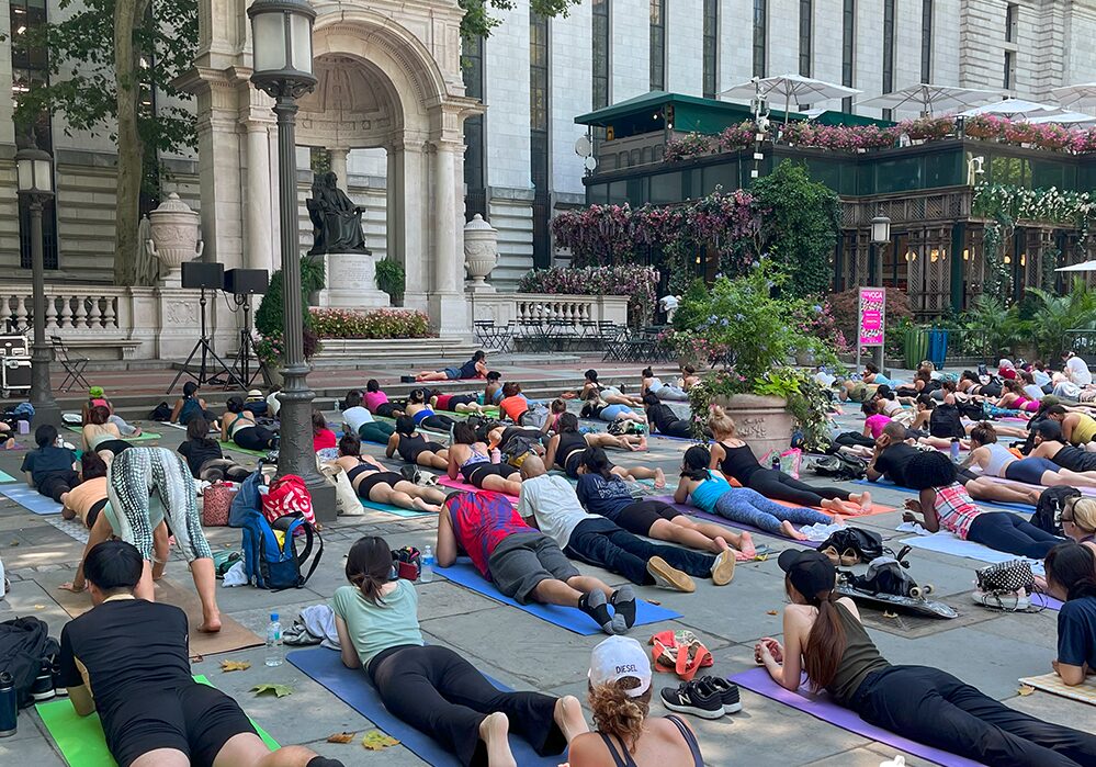 A group of people doing yoga on the ground.